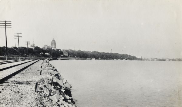 View from railroad bed along Monona Bay shoreline. The Wisconsin State Capitol dome is under construction. St. Raphael's Cathedral can be seen on the left.