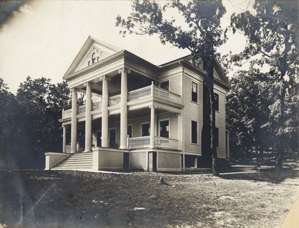 Classical Revival-style porch and facade.  Three-story house with the basement partially above ground.