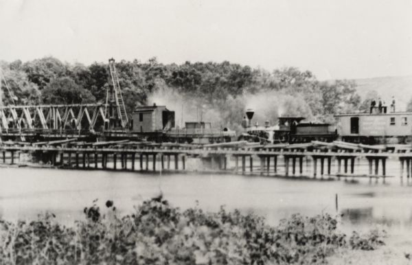 Partial removal of railroad bridge over Rock River. A train is on a section not being removed in order to transport men and materials.