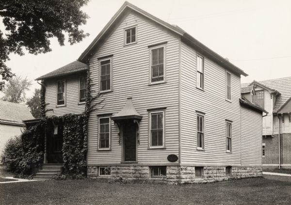 University of Wisconsin-Madison. Site of the first dairy school at a state university, built in 1889. Three-story building, with vines growing on the porch, and a plaque in the lower right.