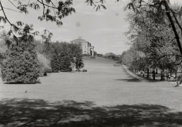 Exterior view of University of Wisconsin-Madison College of Agriculture building on campus, as seen from the west. A car can be seen on a tree-lined road on the right.