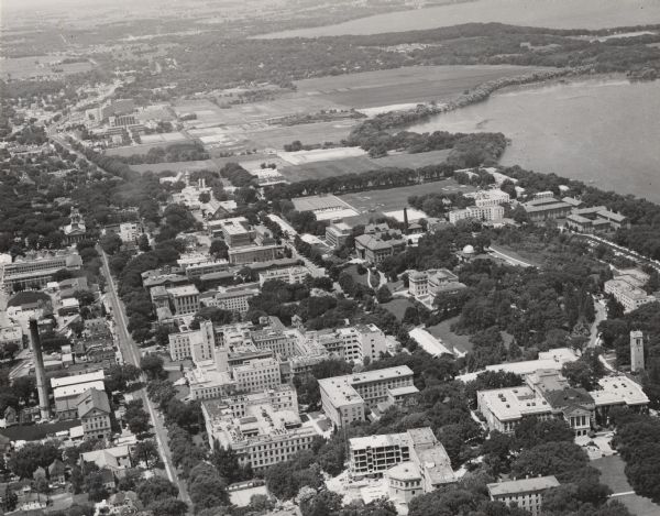 Aerial view over University Avenue of the University of Wisconsin-Madison campus, including University farm in the upper middle. The shoreline of Lake Mendota is on the right, and Bascom Hall is in the lower right corner.