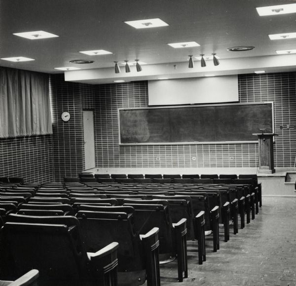 Lecture hall/classroom setting with a podium and a chalkboard in the University of Wisconsin-Madison Bacteriology Laboratory building.