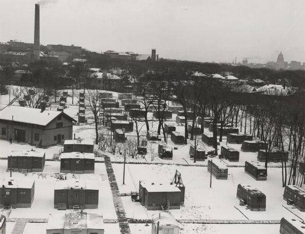Elevated view of married student housing on the University of Wisconsin-Madison campus. There is snow on the ground, a large smokestack on the left, and the Wisconsin State Capitol is in the distance on the right.