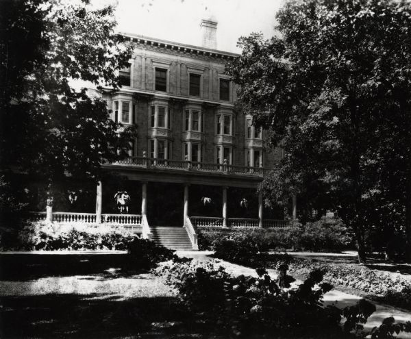 Exterior of Chadbourne Hall on the University of Wisconsin-Madison.  Four-story dormitory with a porch and hanging potted plants.