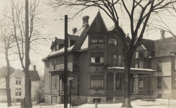 View across road of the "French House" at 1105 University Avenue, on the corner of University Avenue and North Mills Street. The building was demolished about 1964-1965. Previously the Lake residence (1915) and the Roeder residence (1900). Snow is on the ground and the roof.