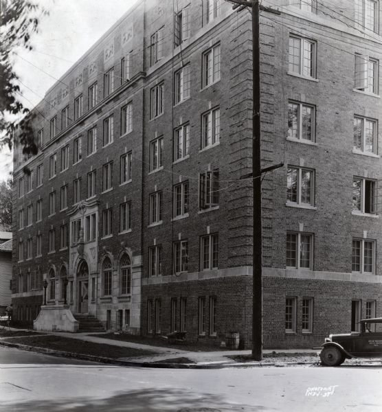 University of Wisconsin-Madison campus. A girls' dormitory, on Langdon Street with an automobile marked as a city vehicle parked on the right.