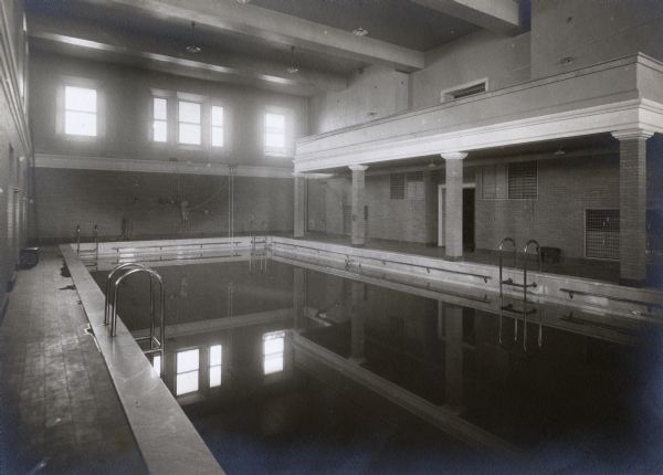 Indoor swimming pool at hall on the University of Wisconsin-Madison campus. The pool area has a balcony on the right, and large windows on the far wall.