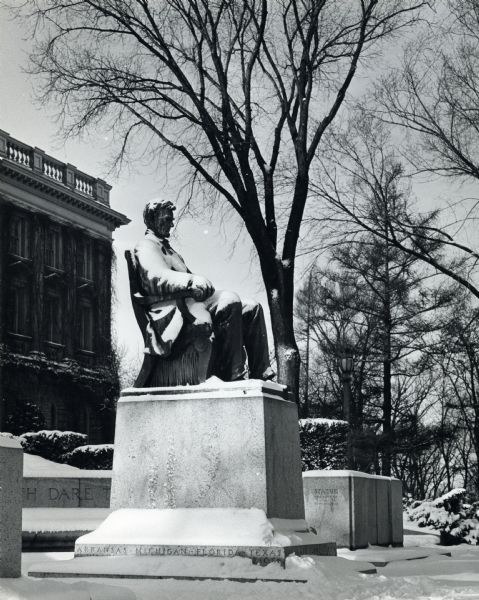Sculpture of Lincoln in front of Bascom Hall on the University of Wisconsin-Madison campus. Bascom Hall is in the background, and snow covers the ground. The base of the statue has state names carved into it.