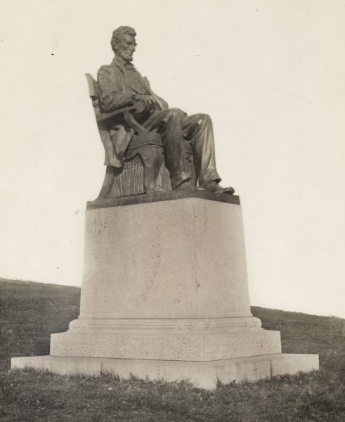 Lincoln Statue on Bascom Hill on the University of Wisconsin-Madison campus. The base of the statue has state names carved into it. The image of the statue including grass has been cut-out onto a white background.