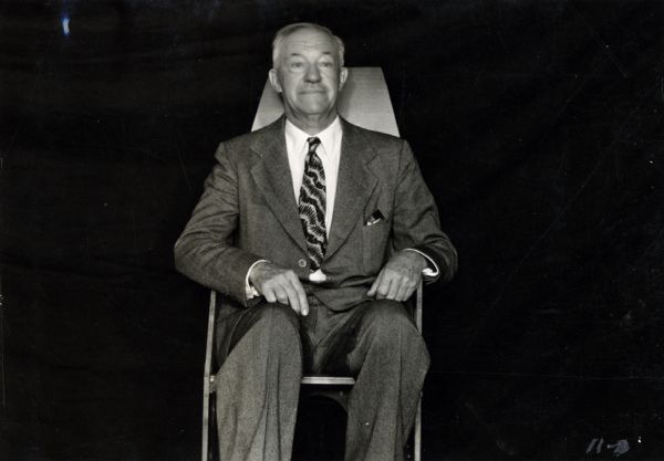 Unidentified executive of the Consolidated Paper Company Plastics Division sitting in a folding transport chair, produced as part of the company's war work.