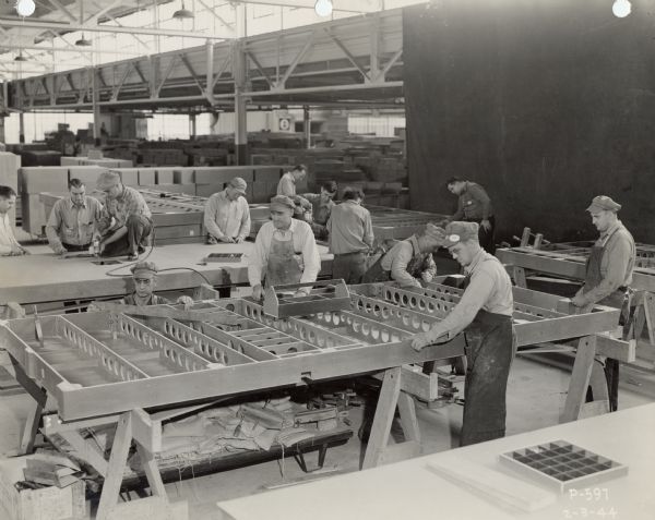 Employees of the Consolidated Paper Company Plastics Division constructing the floors of lightweight gliders to be used by the military.