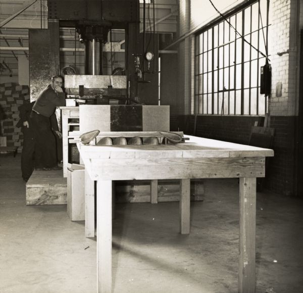 An employee of the Consolidated Paper Company watches what is apparently a test of a part being manufactured by the company as part of its contract to develop lightweight gliders for the military during World War II.