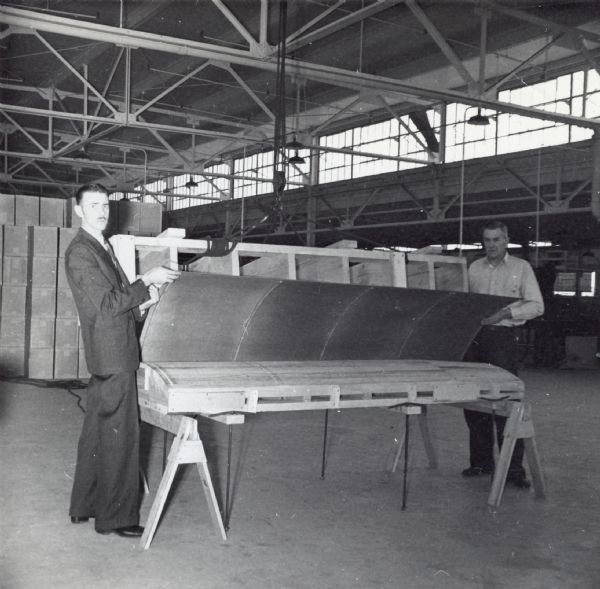 Two employees of the Consolidated Paper Company (Del Rowland and Carl Husome), in a photograph probably taken to demonstrate progress on the development of a prototype for a military glider during World War II.
