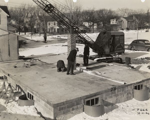Concrete block basement for a factory-built house in Wisconsin Rapids.  The house was a product of the Plastics Division of Consolidated Paper, and it was developed in order to meet the post-World War II need for housing.  The crane seen in the background is on the site to lift the factory-built walls into place.