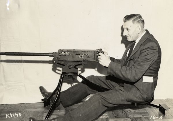Earl Otto, an executive of the Plastics Division of Consolidated Paper, takes a turn during the machine gun test of the laminate plastic panels being developed by the company for military gliders.