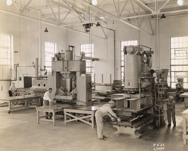 Factory of the Plastics Division of Consolidated Paper Company, showing several of the early laminate presses used for its World War II military production.