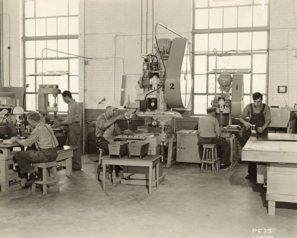 Employees of the Plastics Division of the Consolidated Paper Company demonstrating routers, drill presses, and other equipment used in the fabrication of the paper-based plastic laminate the company manufactured during World War II.