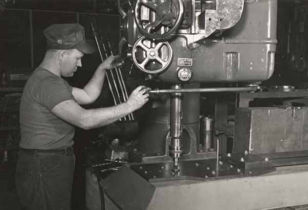 Employee of the Gisholt Company of Madison demonstrating a plastic laminate drill jig manufactured by the Consoweld Company of Wisconsin Rapids.