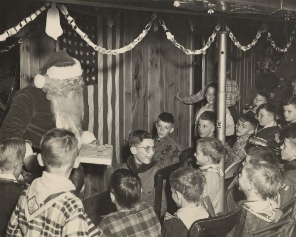 Santa Claus handing out presents at a Christmas party for Wisconsin Rapids Cub Scouts.