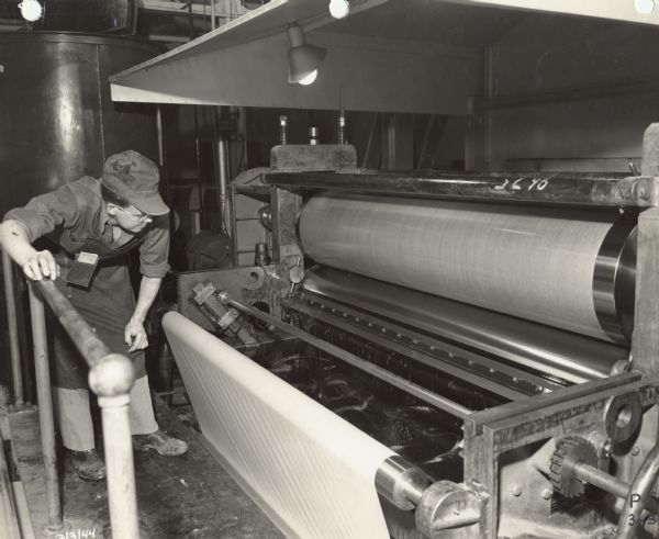 Ken Nelson, an employee of the Plastics Division of Consolidated Papers Company of Wisconsin Rapids, monitors the performance of the #1 Treater.  The machine impregnated paper with plastic which was then fabricated into a laminate used for various products built for the military during World War II.
