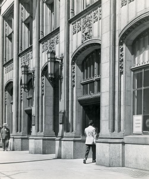 Man walking into the main entrance of the telephone company.