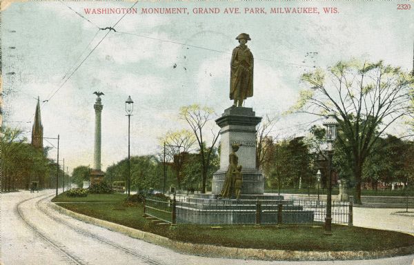 View of the Washington Monument enclosed in a fence on a median. Caption reads: "Washington Monument, Grant Ave. Park, Milwaukee, Wis."