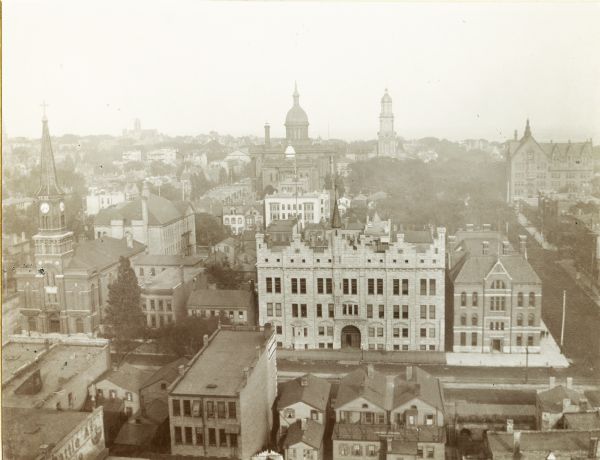 Elevated view of Milwaukee buildings as seen from City Hall, including churches, the Milwaukee Central Police Station and Light Horse Squadron Armory on Broadway Street.