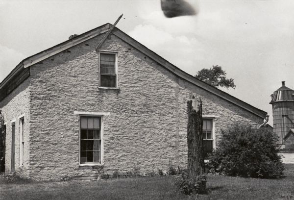 Exterior view of the Dracone Strang house, the Old Voree site. There is a silo in the background.