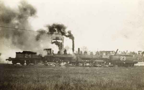 Two railroad cars appear to collide, billowing smoke.