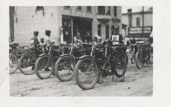 A group of Reading-Standard motorcycles parked on the dirt road.