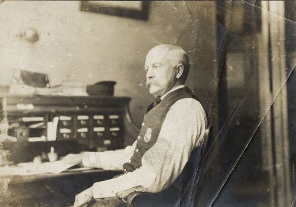Fire Department chief, sitting at a desk in a profile view.