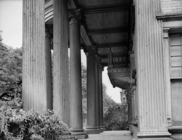Side view of portico with classical columns on front of a mansion.