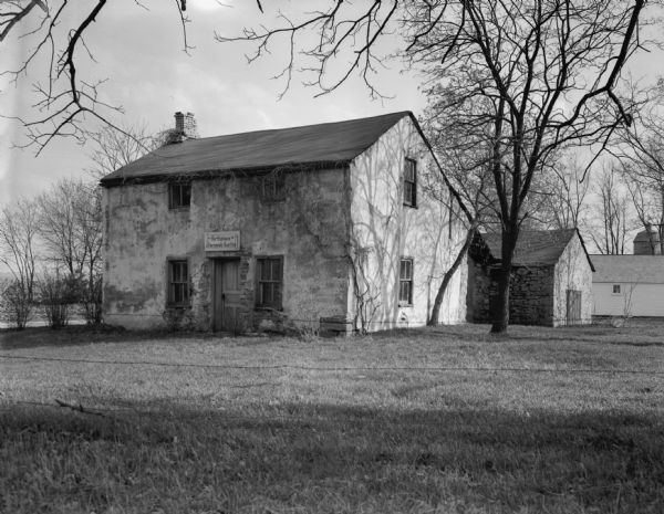 Birthplace of Jeremiah Curtin. There are small buildings and a silo in the background.