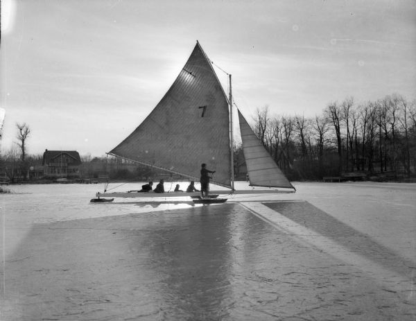 Group of people with an iceboat on a frozen lake (possibly Lake Michigan).