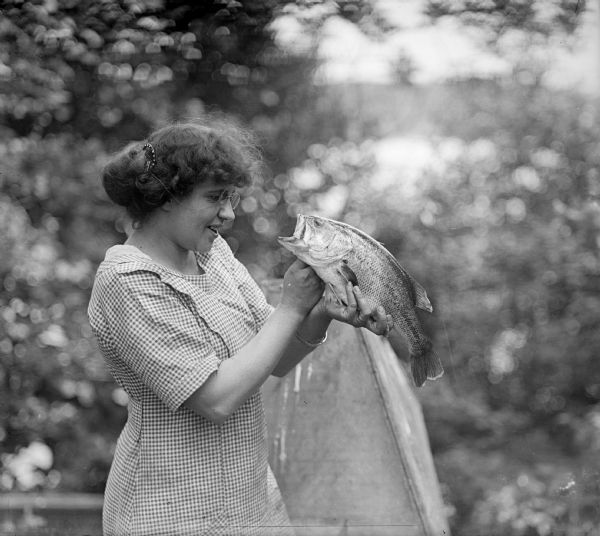 Alma Reinhardt Taylor, the photographer's wife, holding a large-mouth bass.