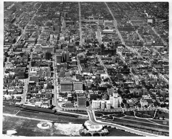 An aerial view of downtown, including a baseball field in the lower left near a train station.