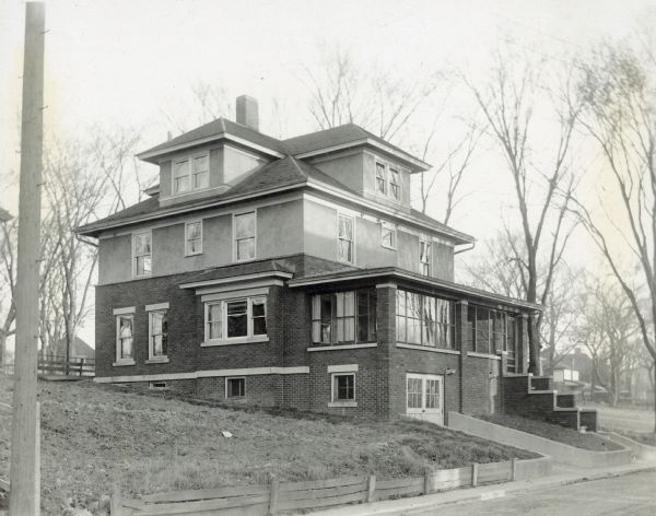 Side view from across the street of the second Madison home of Richard Lloyd Jones, 1010 Walker Court (now 1010 Rutledge Court) showing the yard and the basement level garage.  He was editor and publisher of the Wisconsin State Journal.
