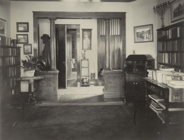 The library of the Richard Lloyd Jones residence, 1010 Walker Court (now 1010 Rutledge Court)  He was editor and publisher of the <i>Wisconsin State Journal</i>. A Victrola-style phonograph stands in the corner.  The menorah on the bookcase was purchased by Georgia Lloyd Jones in New York.  Framed views of Venice hang on the wall.