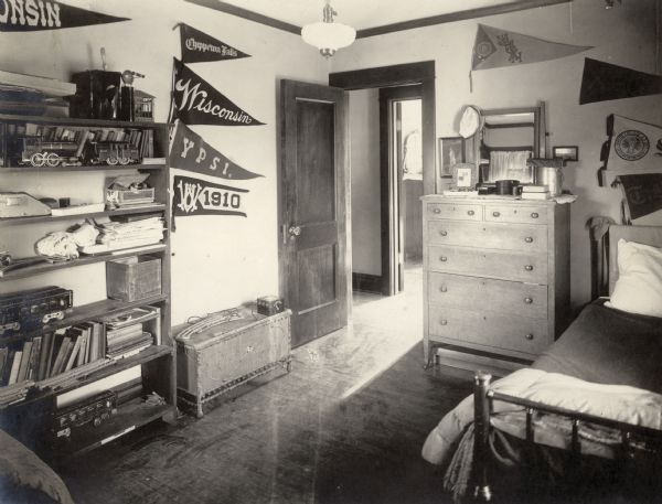 The boys' bedroom in the Richard Lloyd Jones residence, 1010 Walker Court (now 1010 Rutledge Court).  Several pennants, including Chippewa Falls, Wisconsin, and Ypsilanti decorate the walls.  There is a toy locomotive on the bookcase.