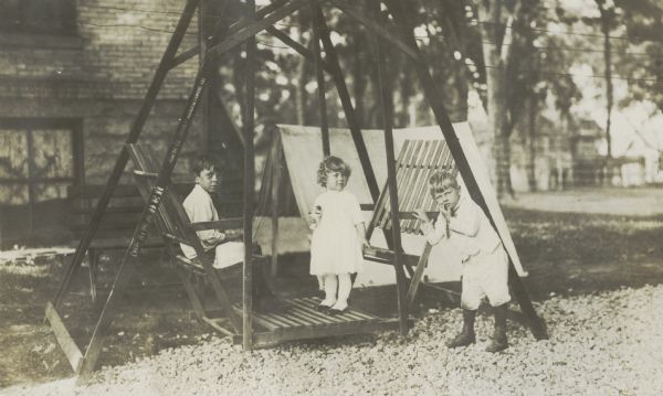 Richard "Dick" Lloyd Jones, Florence Lloyd Jones (Bis or Bisser) and Jenkin Lloyd Jones outside on a platform swing.