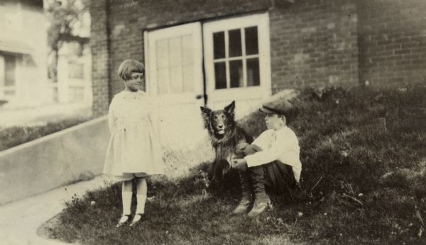 Florence (Bis) and Richard "Dick" Lloyd Jones Jr. with their dog, Blig, a Belgian Shepherd, behind their house on Walker Court.