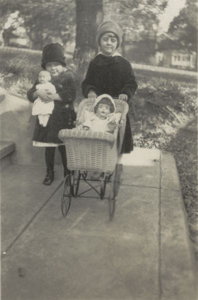 Florence (Bis) Lloyd Jones pushes a doll in a buggy with an unidentified girl with a doll walking alongside.