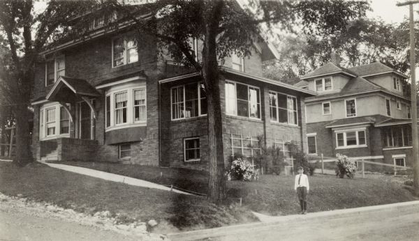 Richard "Dick" Lloyd Jones stands on Walker Court beside house at 617 S. Brearly Street.  The Jones family home is in the background.