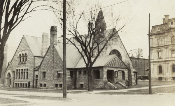 Unitarian Church, built in 1886, and parish hall added in 1911 (both demolished), 125 Wisconsin Avenue at East Dayton Street, with a corner of the Federal Courthouse / U.S. Post Office building on the right.