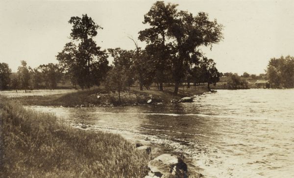 Yahara River flowing out of Lake Kegonsa. There appears to be a boat house on the shoreline in the background.