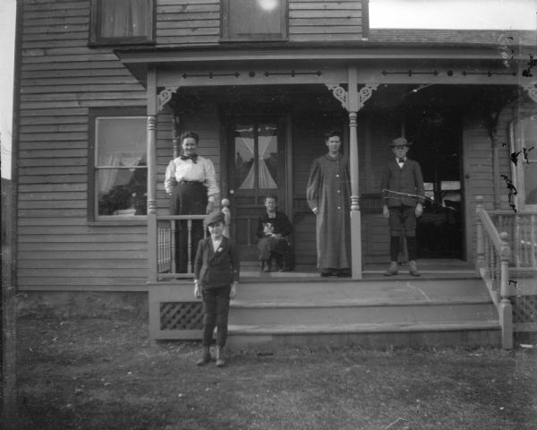 Exterior of the Orlando Mathews home with family on front porch. Mathews was a Civil War veteran, later serving as county treasurer of Adams County.
