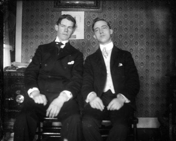 Interior portrait of two men, including the photographer, Otto Lindner. In the background is a large safe.