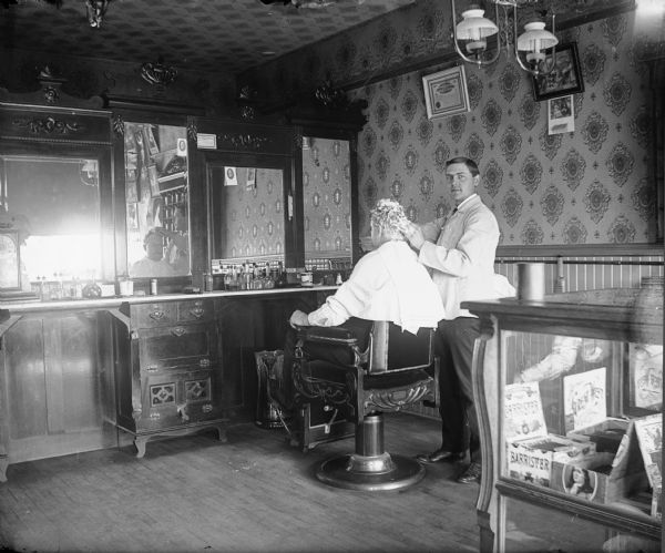 Interior of barber shop with barber and customer. Possibly Coloma, Wisconsin.