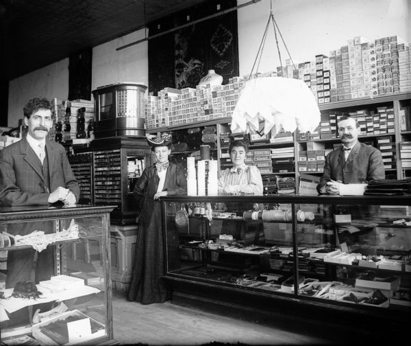 Interior of mercantile store with staff behind counters.